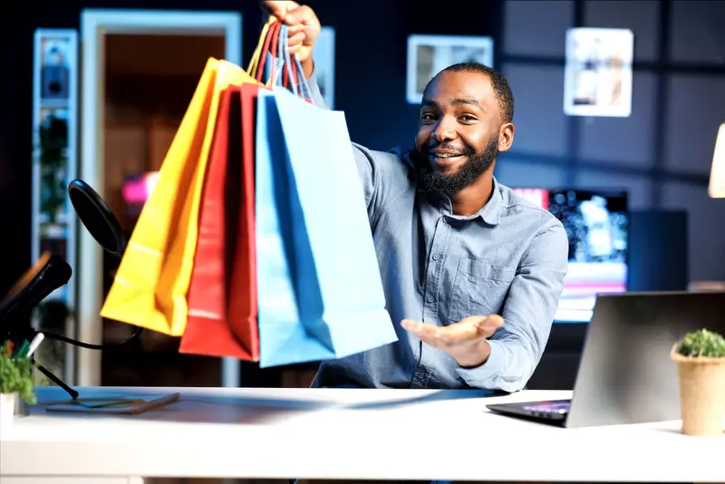Un client souriant tend des sacs de courses colorés